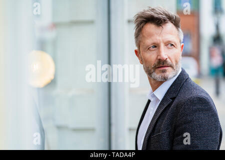 Portrait of mature businessman with greying beard watching something Stock Photo