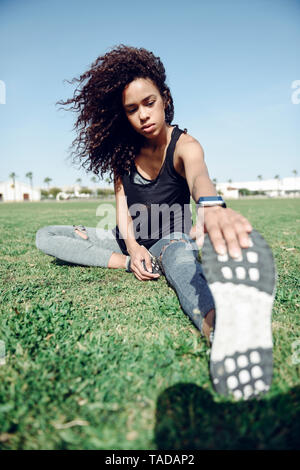 Sporty young woman stretching outdoors Stock Photo