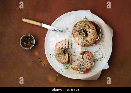 Bagels with sesame pesto, tomatoes, onions and thyme Stock Photo