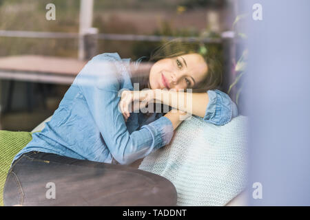 Portrait of a woman behind windowpane at home Stock Photo