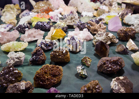 Raw fragments of different precious and semiprecious stones and gems chaotically scattered on the table Stock Photo