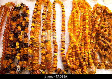 Sun stone, a number of amber necklaces and wrists arranged on a white tablecloth Stock Photo