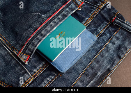 passport and wallet in jeans pockets isolated on black background Stock Photo