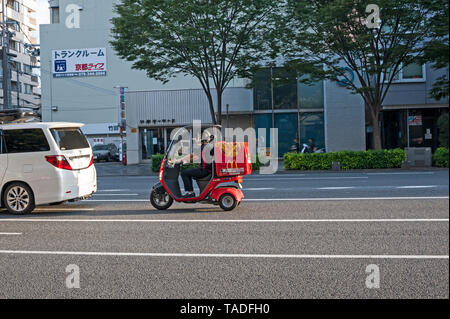 Mcdonalds Delivery Driver On A Red Scooter On A Tokyo Street