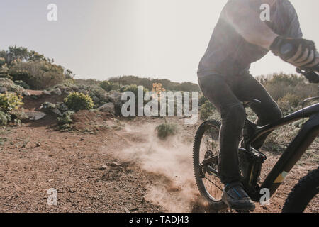 Spain, Lanzarote, partial view of mountainbiker on a trip in desertic landscape Stock Photo
