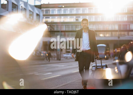 Businessman with suitcase on the move in the city Stock Photo