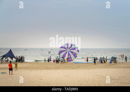 My Khe beach, Da Nang city, Vietnam - April 28, 2019: Parasailing at My Khe beach in Da Nang city. Popular entertainment for holiday travelers Stock Photo