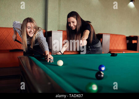 Two happy friends playing billiards together Stock Photo