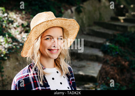 Young blond woman with straw hat Stock Photo