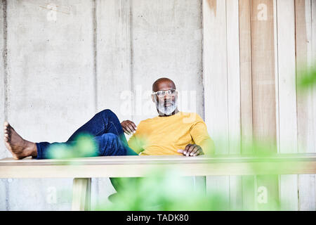 Casual mature businessman sitting at desk in office with feet up Stock Photo