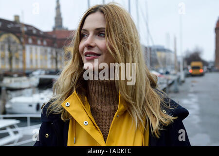 Denmark, Copenhagen, portrait of happy woman at city harbour Stock Photo