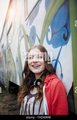 Portrait of happy teenage girl at a painted train car Stock Photo