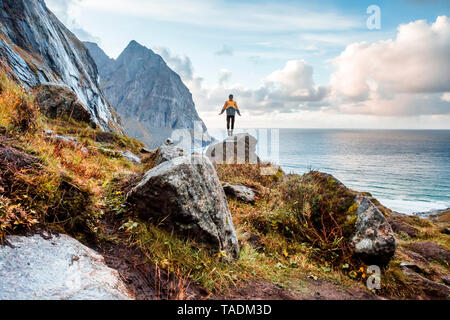 Norway, Lofoten Islands, hiker standing on rock Stock Photo