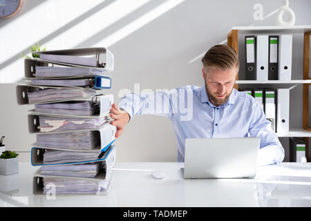Businessperson Pushing Paper Documents Away And Working With Digital Documents On Computer Instead Stock Photo