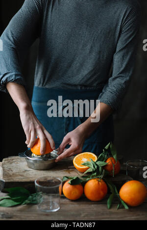 Young man squeezing orange, partial view Stock Photo