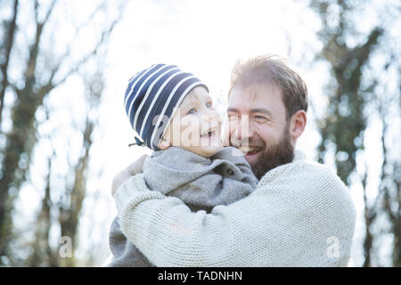 Portrait of happy father carrying son in park Stock Photo