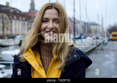 Denmark, Copenhagen, portrait of happy woman at city harbour Stock Photo