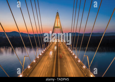Budapest, Hungary - Aerial view of the beautiful cable-stayed Megyeri Bridge over River Danube with blue and orange sky after sunset Stock Photo