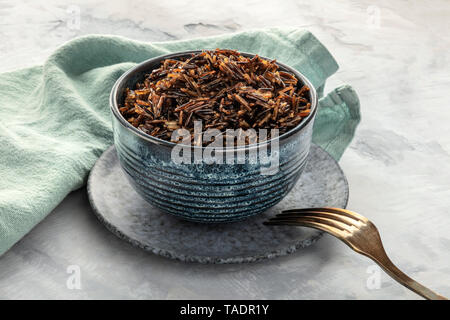 Cooked wild black rice in a bowl, with a fork and a place for text Stock Photo