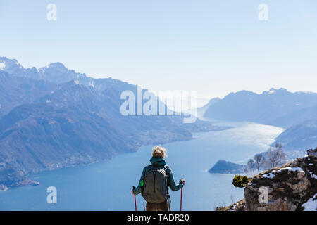 Italy, Como, Lecco, woman on a hiking trip in the mountains above Lake Como enjoying the view Stock Photo