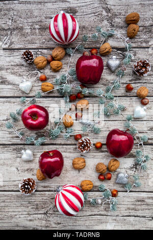 Christmas apples, walnuts, hazelnuts and Christmas decoration on wood Stock Photo