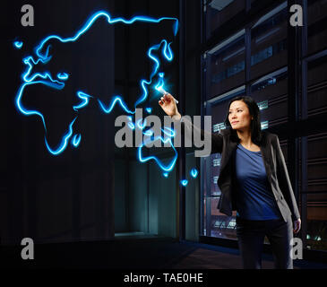 Businesswoman painting a worldmap with light, pointing on Japan Stock Photo