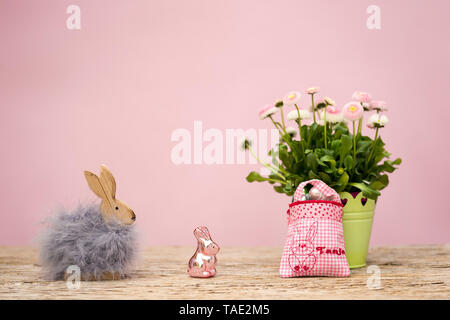 A small bag with the name Tanja embroidered is filled with a small gift. It's Easter, an Easter bunny with fur and a glass of Easter bunny standing on Stock Photo