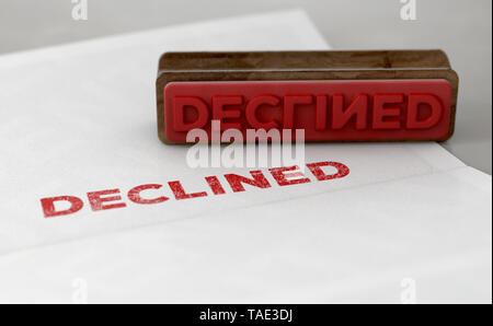 A wooden stamp with embossed text stamping the word declined on a form - 3D render Stock Photo