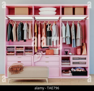 modern pink wardrobe with clothes hanging on rail in walk in closet design interior, 3d rendering Stock Photo