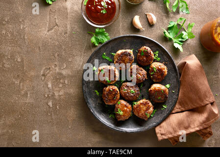 Tasty homemade cutlets from minced meat on plate over brown background with copy space. Top view, flat lay Stock Photo