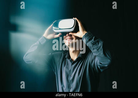 The young man wore virtual glasses and rejoices in the image that he sees Stock Photo