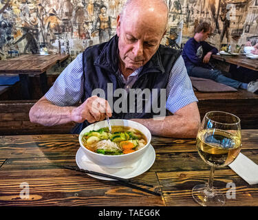 Fam Dang Vietnamese restaurant interior in Torstasse, Mitte-Berlin. Senior elderly man eating bowl of soup Stock Photo