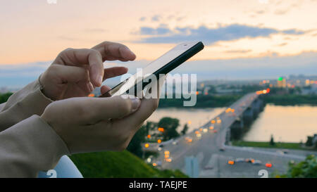 Woman using smartphone in the city after sunset Stock Photo