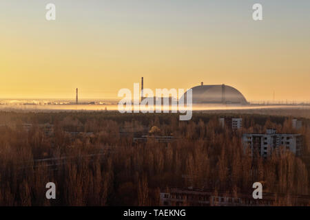 Cityscape view of Pripyat, Ukraine, inside the Chernobyl Exclusion Zone, with the Chernobyl Reactor in the background Stock Photo