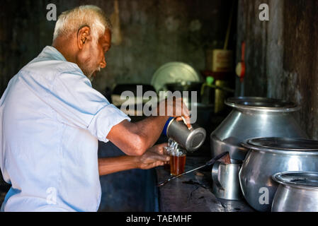 Horizontal portrait of a man making tea in India. Stock Photo