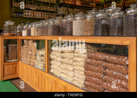Horizontal close up of rows of jars containing nuts and spices on sale in a shop in India. Stock Photo