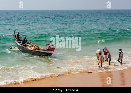 Horizontal view of local fishermen rowing out to sea in Kerala, India. Stock Photo