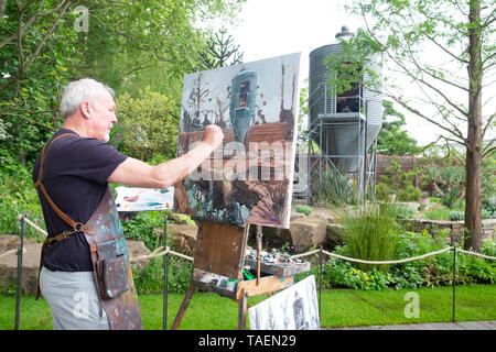 Artist, Gerard Byrne, paints 'The Resilience Garden' designed by Sarah Eberle, Built by Crocus at The Chelsea Flower show. Stock Photo