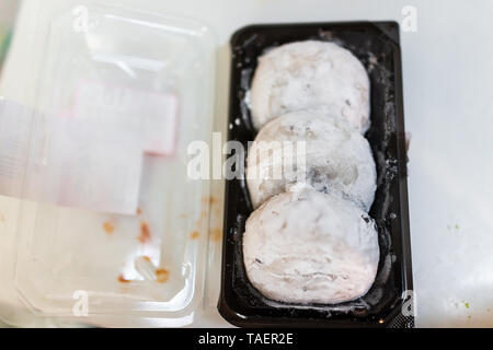 Three round whole pieces of mochi sticky glutinous rice cake dessert wagashi daifuku filled with red bean adzuki jam filling storebought packaged Stock Photo