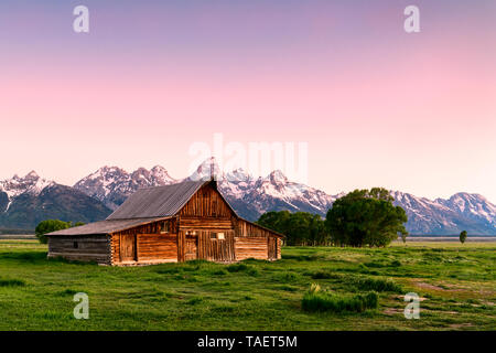 An old barn along Mormon Row with the Grand Tetons in the background near Jackson Hole, Wyoming USA. Stock Photo