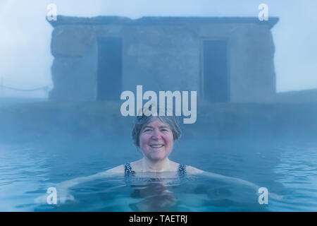 Karen Rentz soaking in the Secret Lagoon, a natural hot springs in Fludir, Iceland Stock Photo