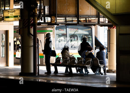 Utsunomiya, Japan - April 4, 2019: Train station platform for shinkansen or local line and people waiting sitting on bench Stock Photo
