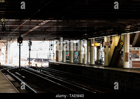Utsunomiya, Japan - April 4, 2019: Train station platform for shinkansen or local line and dark covered architecture with light and tracks Stock Photo