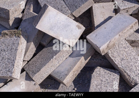 Pile of dirty gray curb bricks. background, texture. Stock Photo