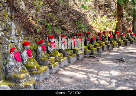 Famous red Jizo statues in Kanmangafuchi Abyss, Nikko, Tochigi in Japan with bibs many figures protecting the dead Stock Photo