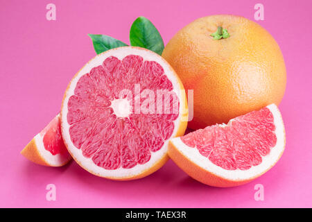 Grapefruit and grapefruit slices isolated on pink background. Stock Photo