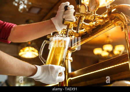 Bartender hands pouring light  beer in a beer glass Stock Photo