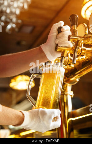 Bartender hands pouring light  beer in a beer glass Stock Photo