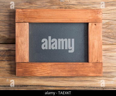 Blackboard with wooden frame on wooden background. Stock Photo