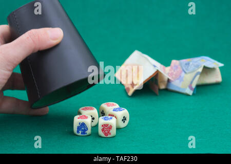Someone playing dice on a green mat with tickets for bets in the background Stock Photo